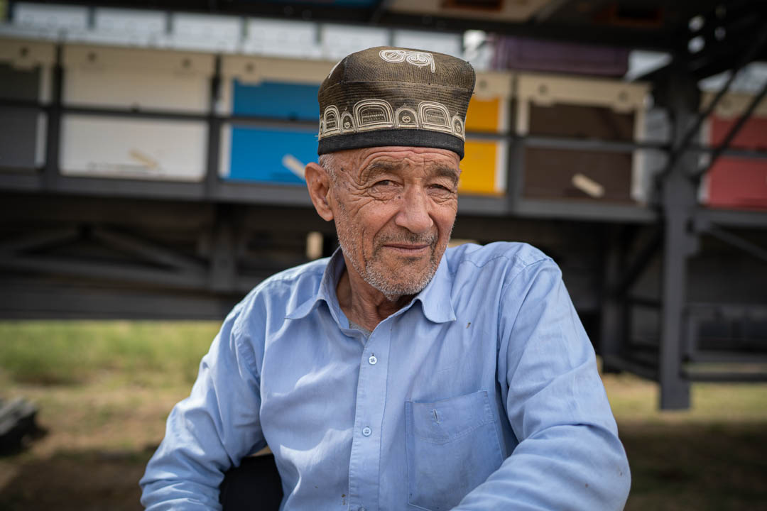 Apiculteur Ouzbek, portant la tubeteika, rencontré sur la route. De nombreuses ruches sont visibles disposés sur des camions. @helene_decaestecker